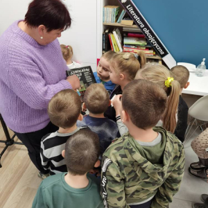 Dyrektor Biblioteki Elżbieta Kuczyńska oprowadza dzieci po bibliotece