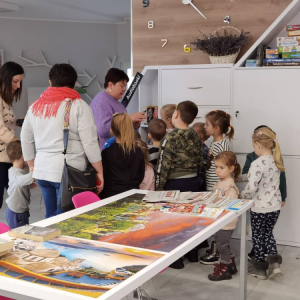 Dyrektor Biblioteki Elżbieta Kuczyńska oprowadza dzieci po bibliotece