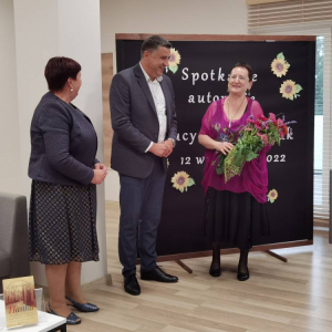 Za zdjęciu od lewej dyrektor biblioteki Pani Elżbieta Kuczyńska, oraz Wójt Andrzej Chabros wręczający kwiaty Pani Lucynie Olejniczak