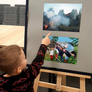 Chłopiec oglądający fotografię na wystawie